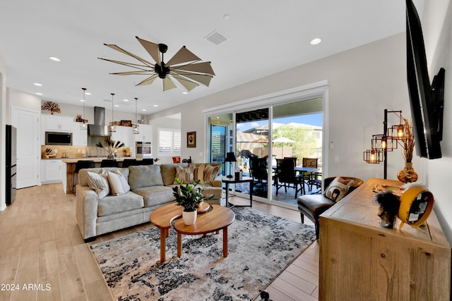 living room featuring ceiling fan and light hardwood / wood-style floors