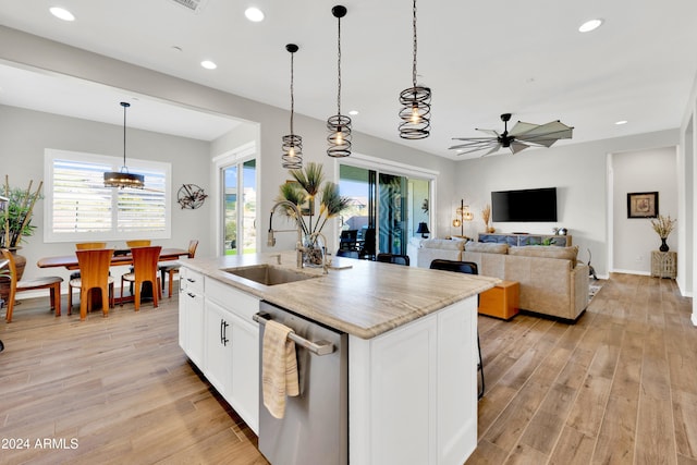 kitchen with stainless steel dishwasher, a kitchen island with sink, sink, light hardwood / wood-style floors, and white cabinetry