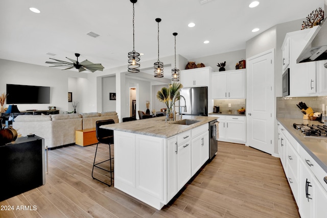 kitchen featuring white cabinetry, a kitchen island with sink, and stainless steel appliances