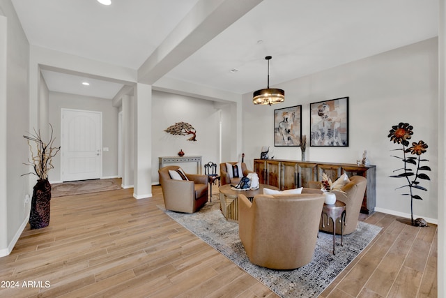 living room with beam ceiling and an inviting chandelier