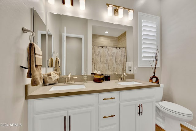 bathroom with curtained shower, vanity, and toilet