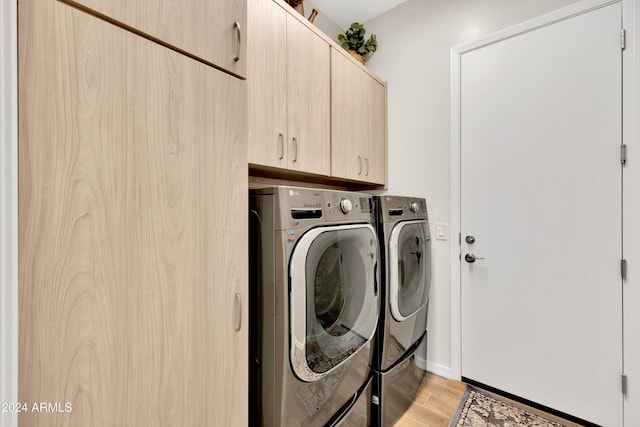 laundry room featuring cabinets, separate washer and dryer, and light hardwood / wood-style flooring