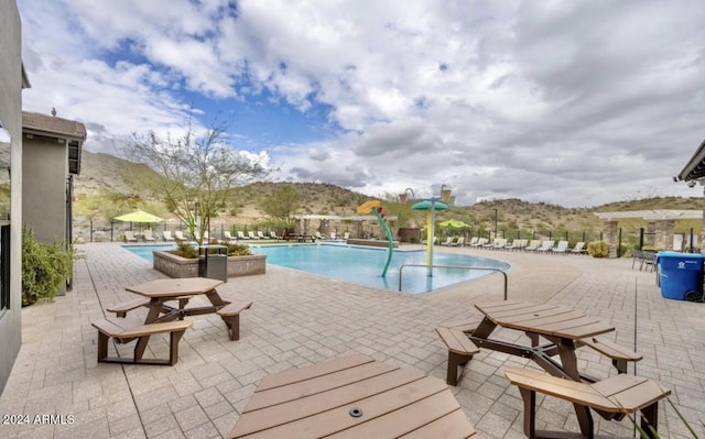 view of swimming pool with a mountain view and a patio