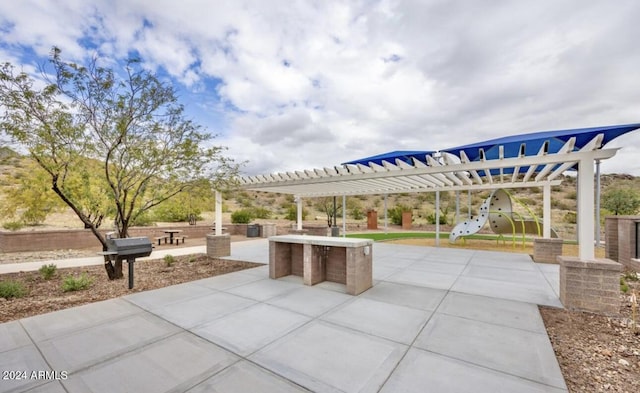 view of patio / terrace featuring a pergola and a playground