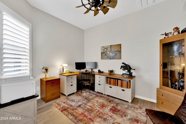 office with light hardwood / wood-style floors and ceiling fan