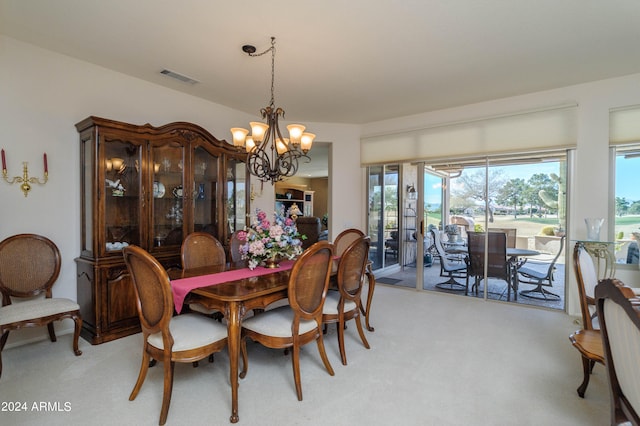 dining space with a chandelier and light colored carpet