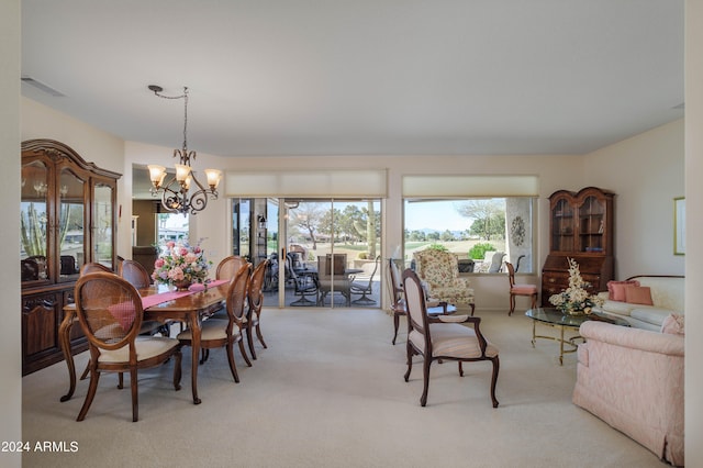 dining area with a notable chandelier and light colored carpet