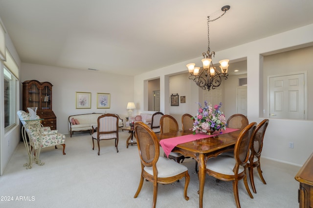 dining area featuring light colored carpet and a chandelier