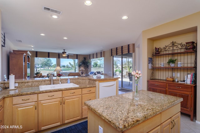 kitchen with ceiling fan, light brown cabinets, sink, a kitchen island with sink, and tile patterned floors