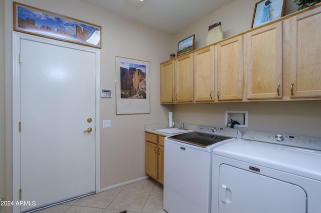 clothes washing area with cabinets, light tile patterned flooring, washer and dryer, and sink