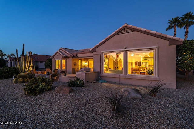 back house at dusk with a patio