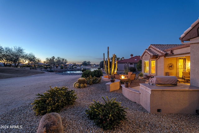 yard at dusk featuring a patio