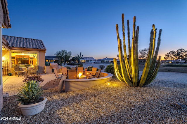 yard at dusk featuring a patio