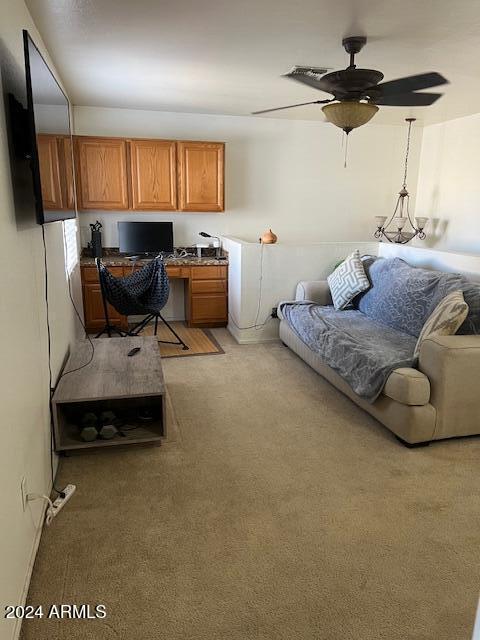 carpeted office with built in desk and ceiling fan