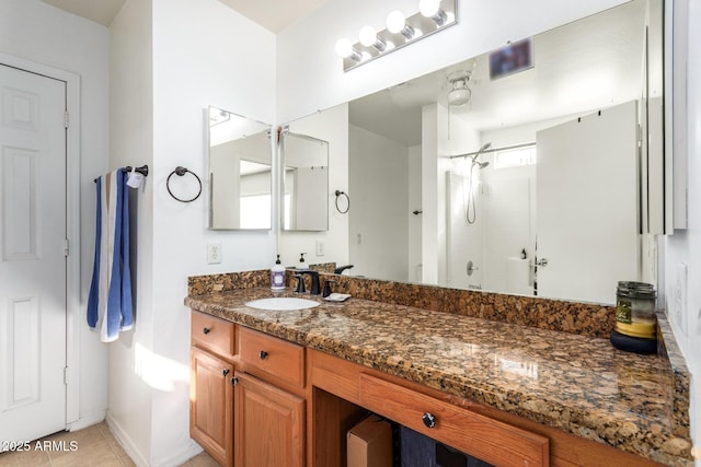 bathroom featuring tile patterned floors, walk in shower, and vanity