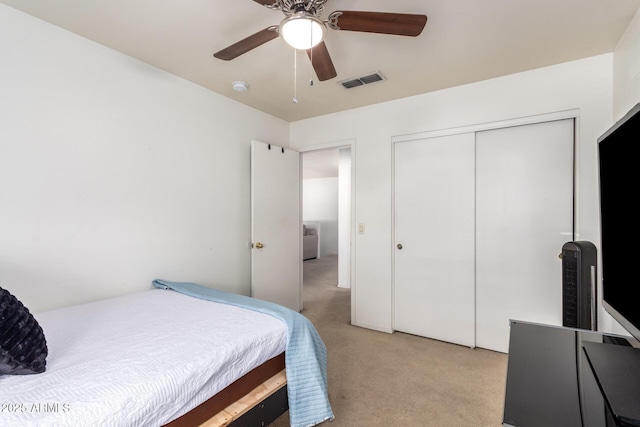 carpeted bedroom with ceiling fan and a closet