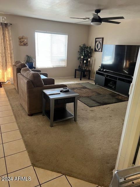 living room featuring ceiling fan and light tile patterned floors