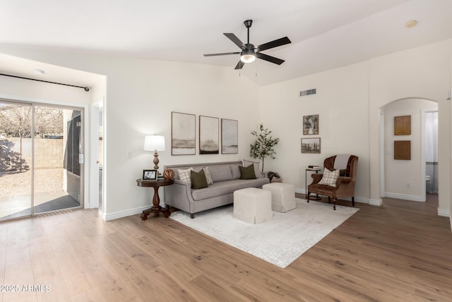 living room featuring hardwood / wood-style flooring, ceiling fan, and vaulted ceiling