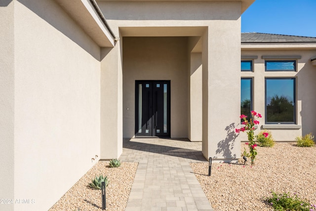 view of exterior entry with a patio area