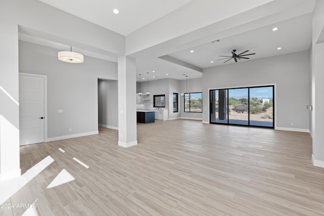 unfurnished living room with light hardwood / wood-style floors and ceiling fan