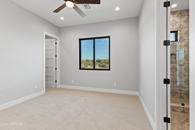 unfurnished room featuring light colored carpet and ceiling fan