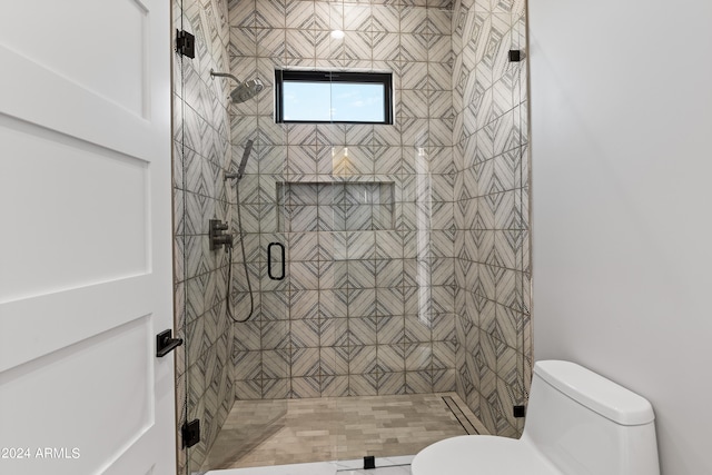 bathroom featuring toilet and a shower with shower door