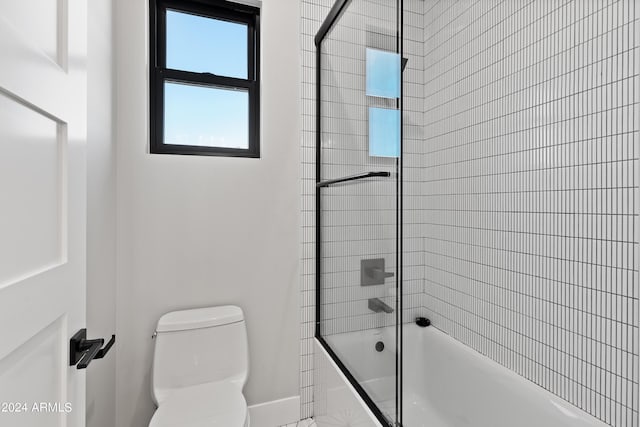 bathroom with tiled shower / bath and toilet