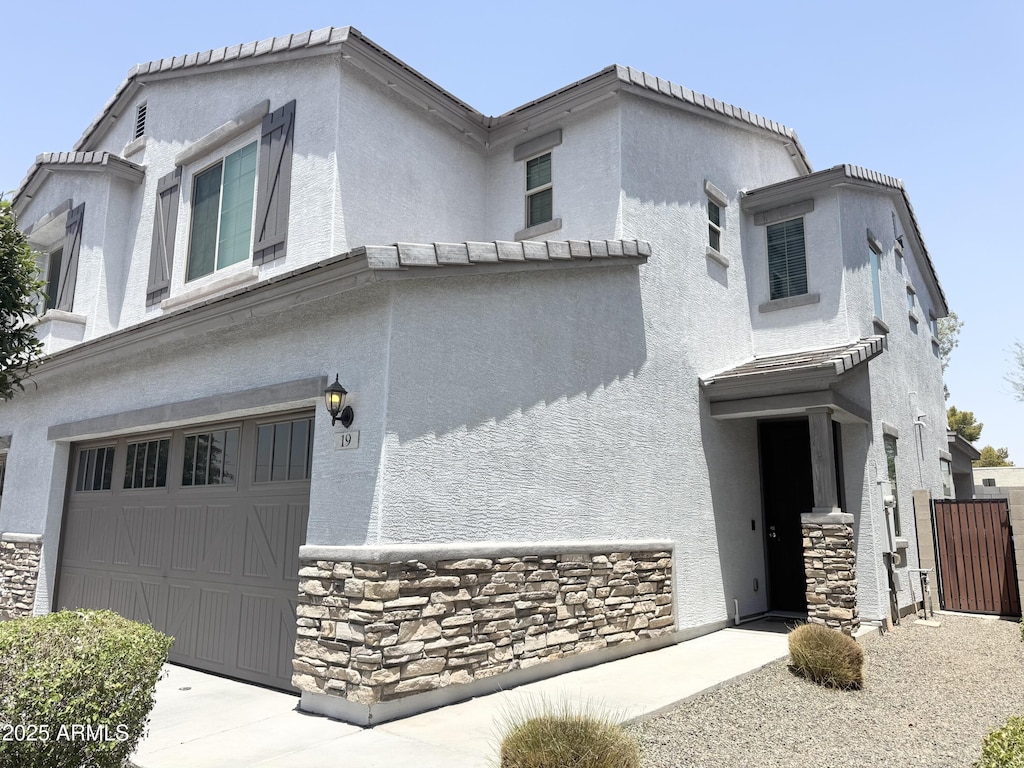 2339 E University Dr Unit 19, Mesa, AZ 85213 - view of front facade with an attached garage, stucco siding, and stone siding