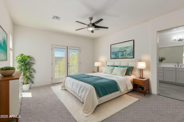 carpeted bedroom with connected bathroom, access to outside, a sink, baseboards, and visible vents