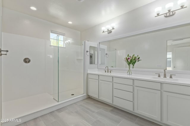 bathroom featuring double vanity, a sink, an enclosed shower, and recessed lighting