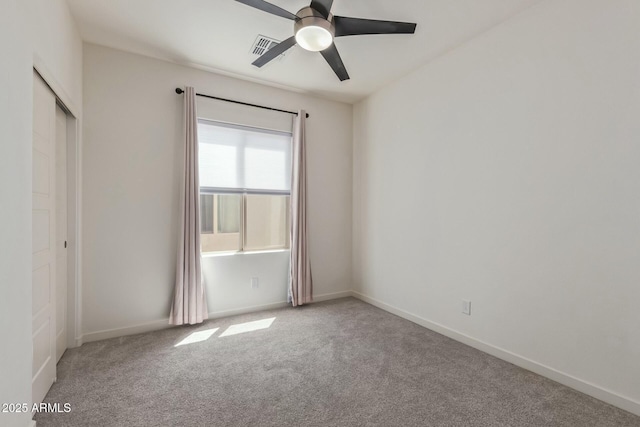 unfurnished bedroom with carpet flooring, ceiling fan, baseboards, visible vents, and a closet