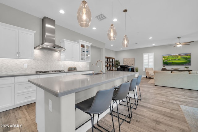 17565 E Blaze Ln, Rio Verde, AZ 85263 - kitchen featuring wall chimney range hood, a sink, gas stovetop, decorative backsplash, and open floor plan
