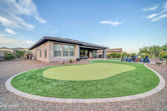 17565 E Blaze Ln, Rio Verde, AZ 85263 - rear view of house with a putting green, a patio, stucco siding, and a fire pit
