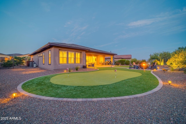 17565 E Blaze Ln, Rio Verde, AZ 85263 - rear view of property with an area to practice putting, central AC unit, and stucco siding