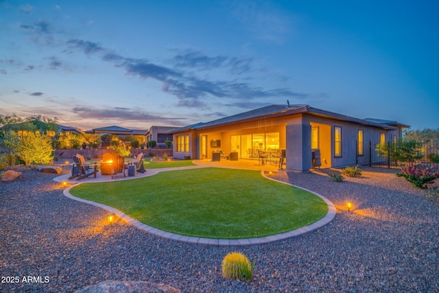 17565 E Blaze Ln, Rio Verde, AZ 85263 - back of property with an outdoor fire pit, a patio, a lawn, and stucco siding