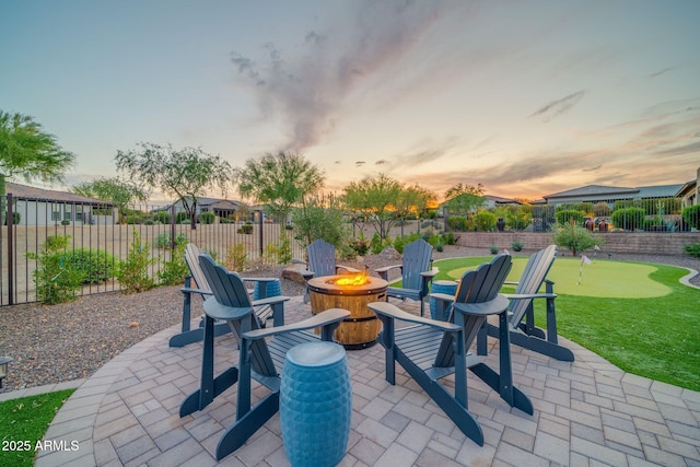 17565 E Blaze Ln, Rio Verde, AZ 85263 - patio terrace at dusk with a putting green, an outdoor fire pit, and a patio area