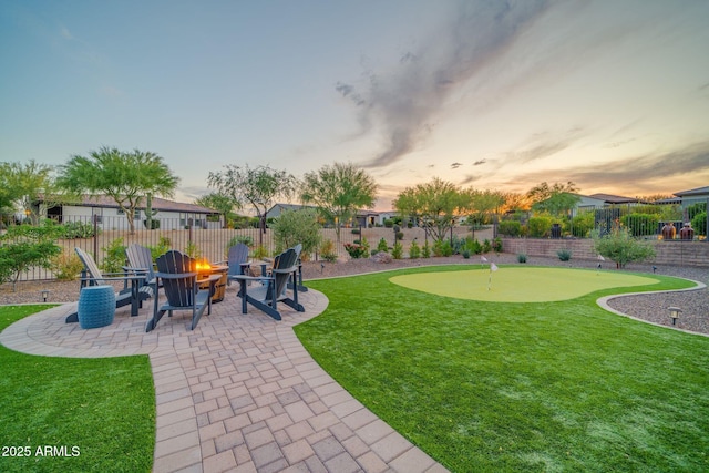 17565 E Blaze Ln, Rio Verde, AZ 85263 - yard at dusk with a putting area, a patio area, and a fire pit
