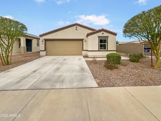 mediterranean / spanish home featuring a garage, concrete driveway, a tile roof, and stucco siding