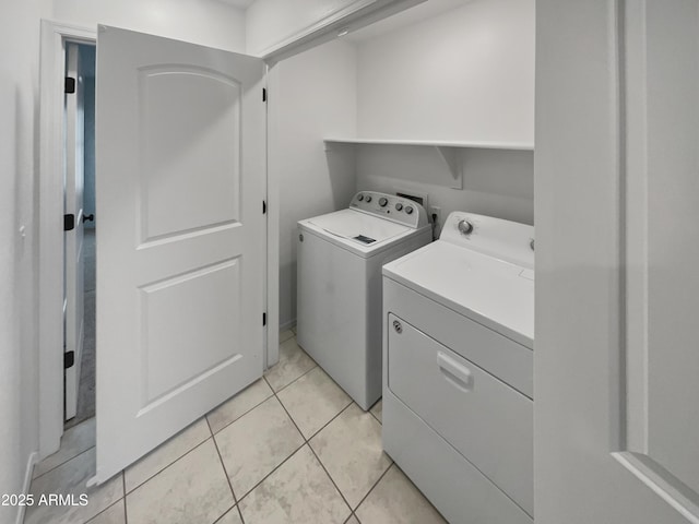 clothes washing area with light tile patterned floors, laundry area, and washing machine and dryer