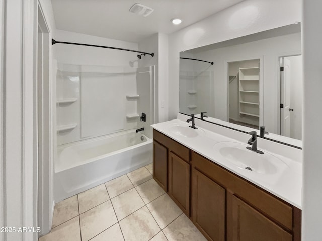 bathroom featuring double vanity, visible vents, a sink, and tile patterned floors