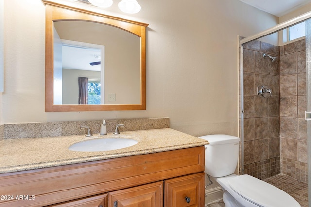 bathroom featuring vanity, toilet, and a tile shower