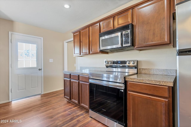 kitchen with dark hardwood / wood-style floors and appliances with stainless steel finishes