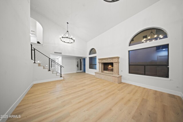 15641 E Sycamore Dr, Fountain Hills, AZ 85268 - unfurnished living room with built in features, wood finished floors, stairs, baseboards, and high vaulted ceiling