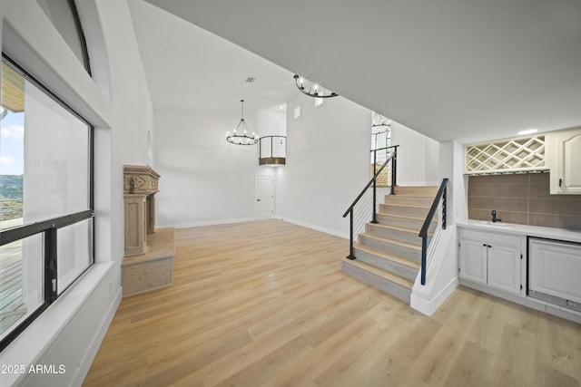 15641 E Sycamore Dr, Fountain Hills, AZ 85268 - stairs with a bar, wood finished floors, baseboards, and a chandelier