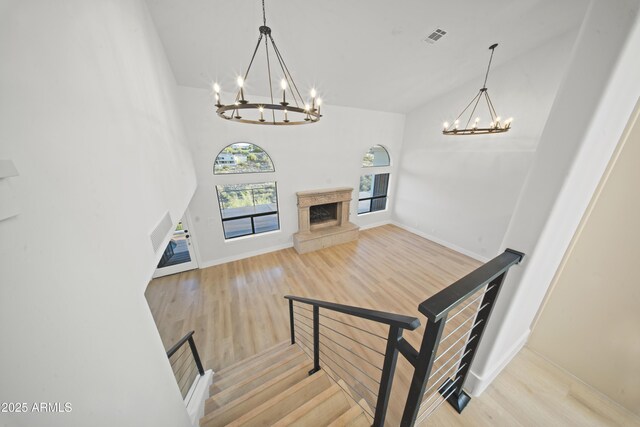 15641 E Sycamore Dr, Fountain Hills, AZ 85268 - staircase featuring a chandelier, wood finished floors, baseboards, and a fireplace