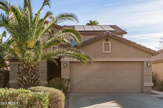 mediterranean / spanish-style home featuring a garage and solar panels