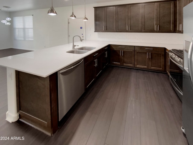 kitchen featuring kitchen peninsula, stainless steel appliances, dark wood-type flooring, and decorative light fixtures