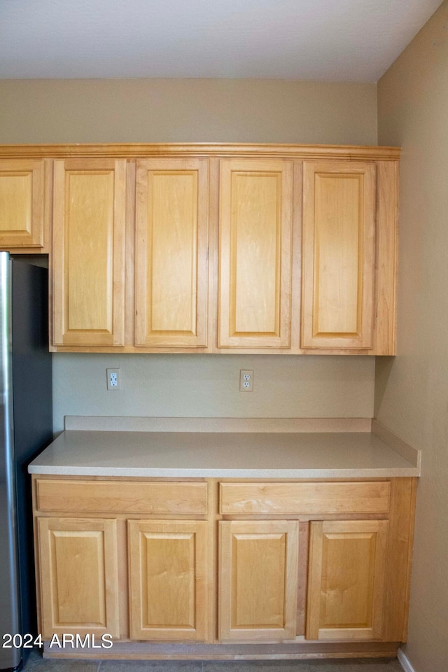 kitchen with stainless steel refrigerator and light brown cabinetry