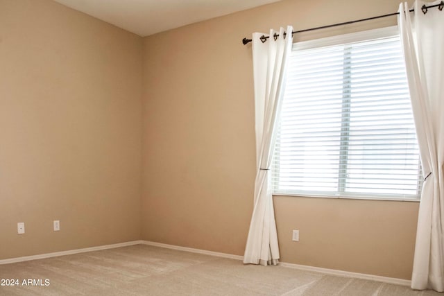 spare room with light carpet and a wealth of natural light