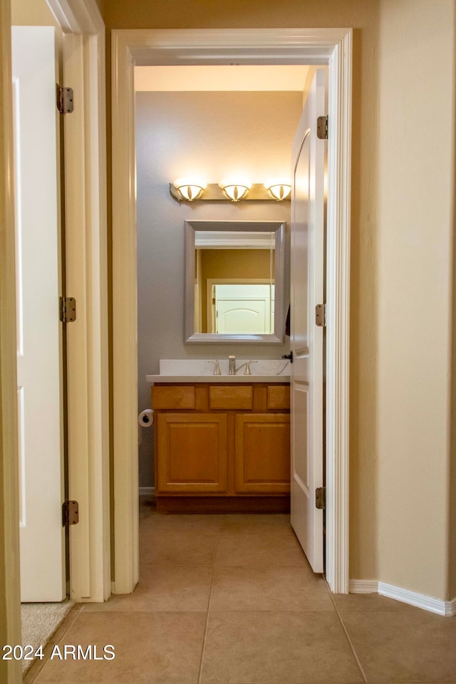 corridor with light tile patterned floors and sink